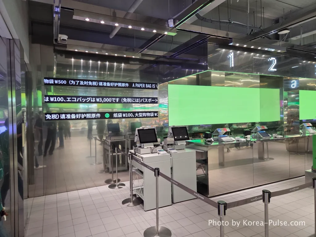 Second floor checkout counter at Olive Young Myeongdong Town with multilingual signs in English Chinese and Japanese and green digital screens showing the counter is closed during a quiet weekday