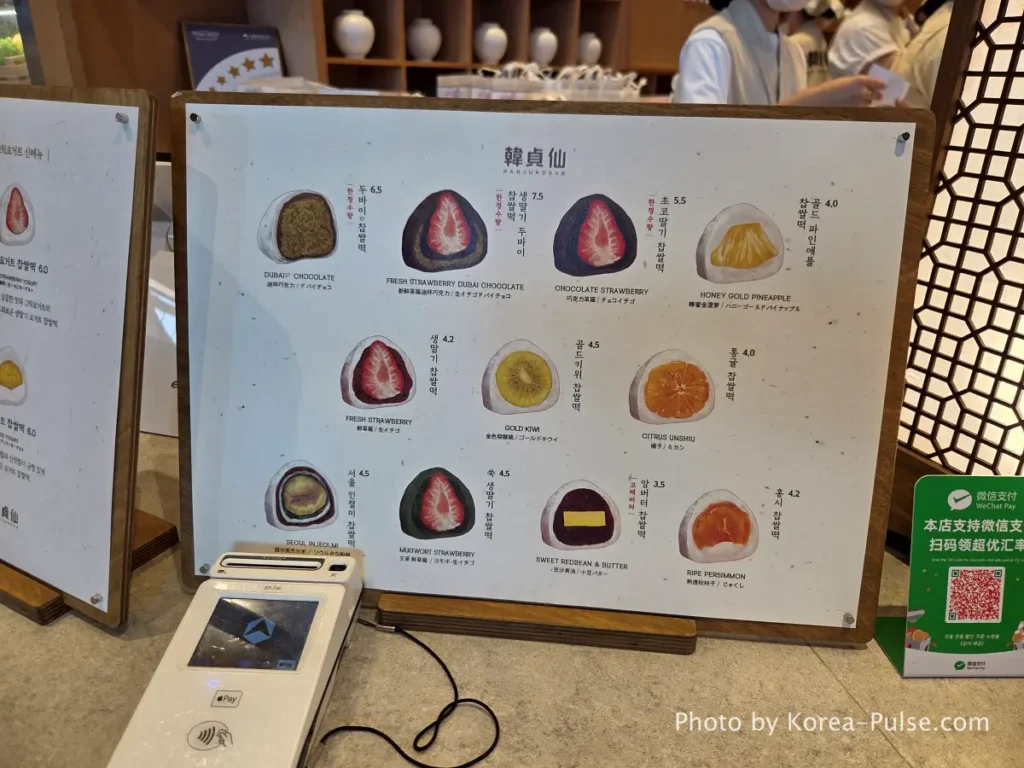 Hanjunson menu board showing premium fruit chapssal tteok varieties including fresh strawberry gold kiwi and Dubai chocolate