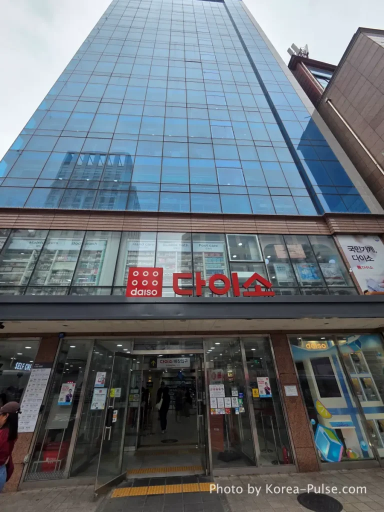 Daiso Myeongdong, Floor by FloorA 12-Story Shopping Survival Guide 2 Daiso Myeongdong Station branch main entrance facade close-up blue glass tower building Seoul