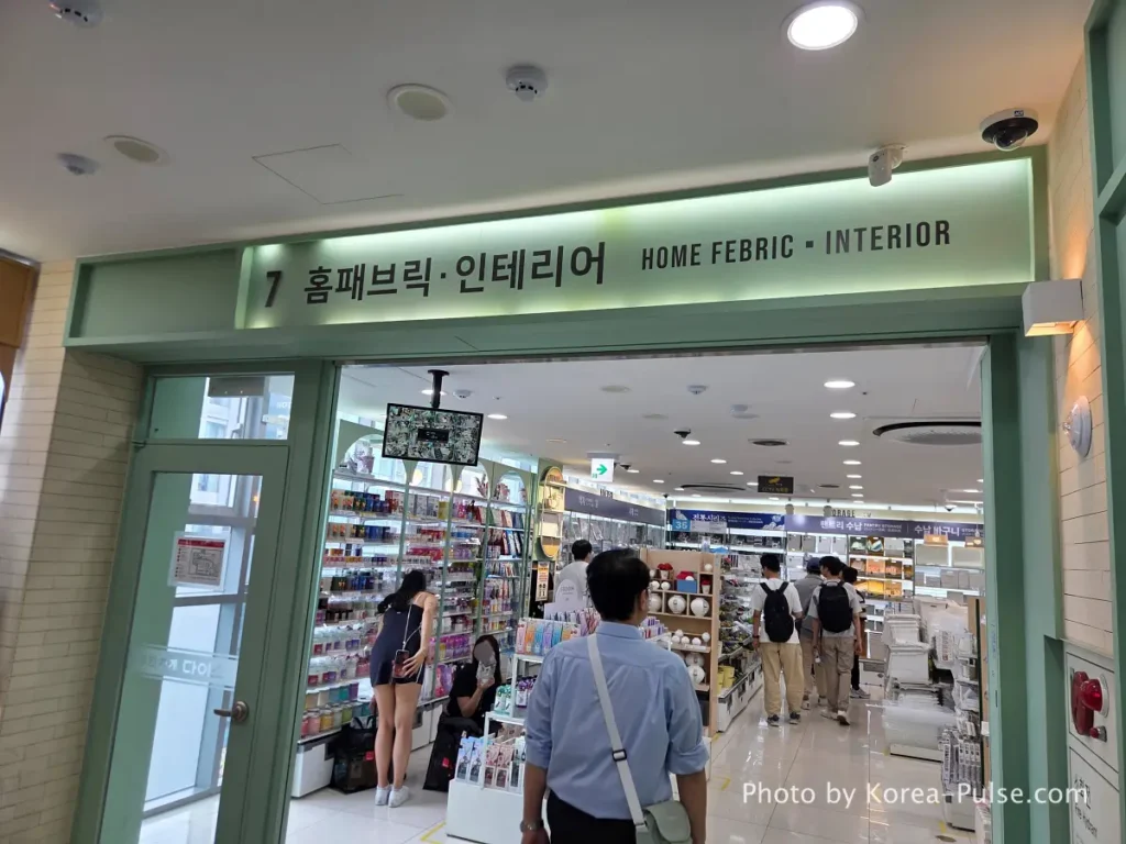 Daiso Myeongdong, Floor by FloorA 12-Story Shopping Survival Guide 17 https://korea-pulse.com/wp-content/uploads/2026/05/20260526_122228.webp" alt="Daiso Myeongdong Station branch 7th floor home fabric and interior section entrance sign Seoul