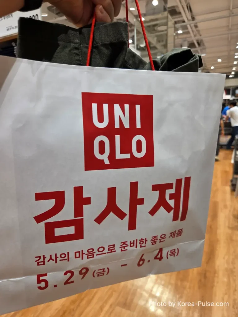 Uniqlo Thank You Festival in Seoul: I Went for One Thing and Bought Another (No Regrets) 10 A Uniqlo paper shopping bag printed with the bold red Gamsaje 감사제 branding and sale dates May 29 to June 4, held up inside the store