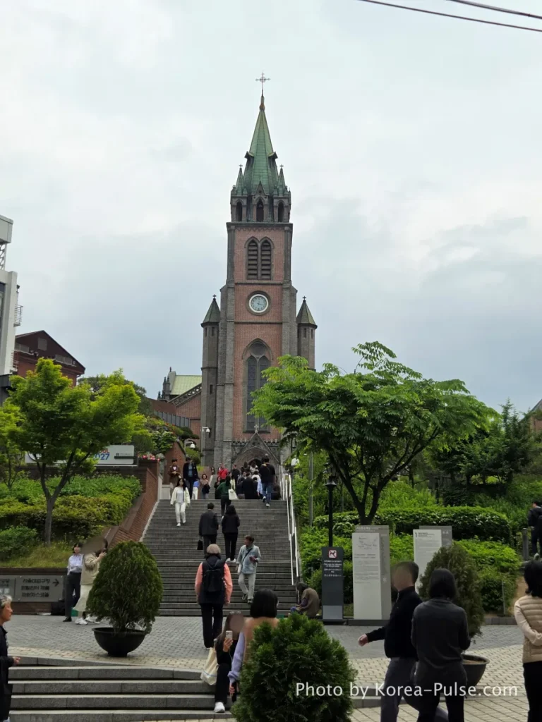 Myeongdong Street in May: Where Seoul's Best Food Hides in Plain Sight 1 Myeongdong Cathedral rising above stone steps in Seoul on a May afternoon — a peaceful landmark at the heart of Myeongdong street