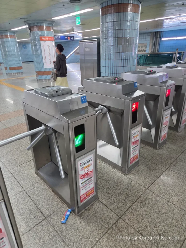 Passenger tapping single journey ticket at Seoul Metro fare gate to enter subway station