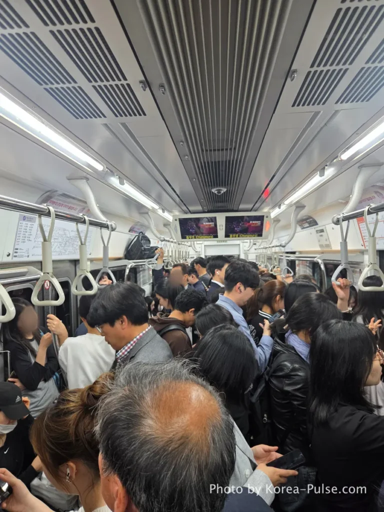 Crowded Seoul Metro Line 3 train packed with standing passengers during rush hour commute. Seoul Subway Guide: Rush Hour on Line 3