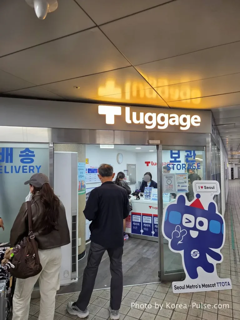 Seoul Station Luggage Storage:T-luggage vs. Zimcarry 2 Customers queuing at T-luggage Metro Carrier Service counter at Seoul Station with TTOTA mascot standee