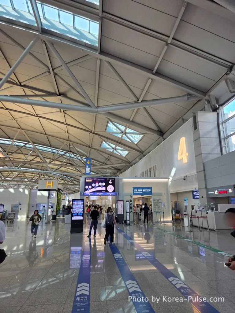 Incheon Airport Terminal 1 wide departure hall with high glass ceilings and moving walkways