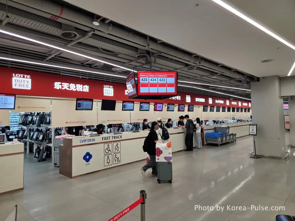 Incheon Airport duty-free collection counter with staff handling pre-ordered packages for passengers