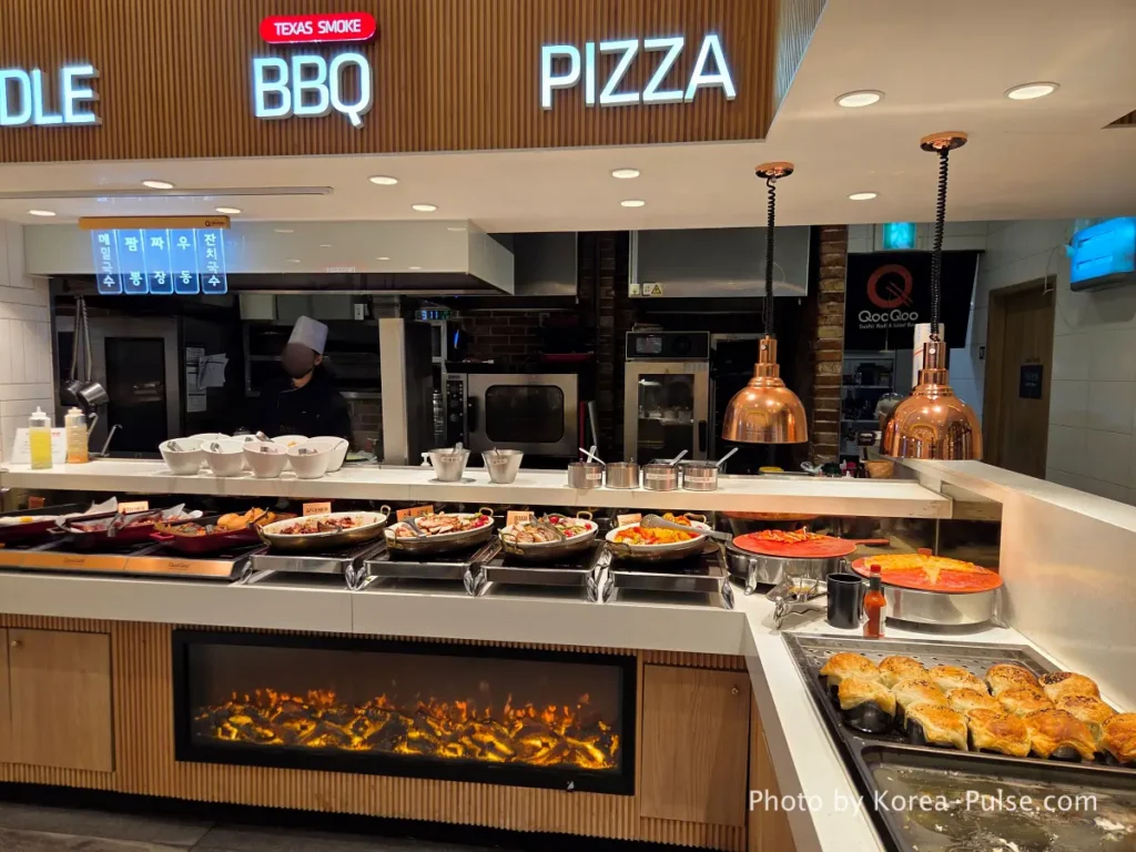 The 120-Dish Question: Inside QooQoo, Korea's Sushi Buffet Phenomenon 4 Pizza BBQ and noodle station signs at QooQoo buffet
