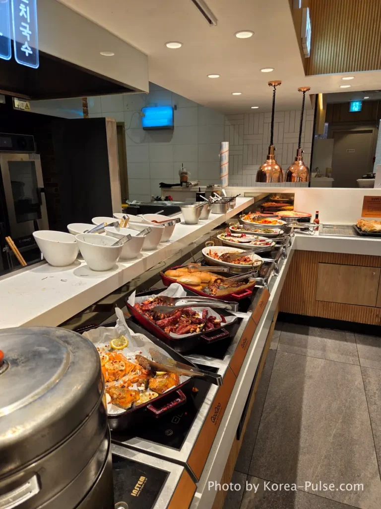 The 120-Dish Question: Inside QooQoo, Korea's Sushi Buffet Phenomenon 8 Korean BBQ zone with grilled meats and copper hoods at QooQoo buffet