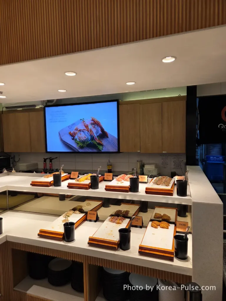 The 120-Dish Question: Inside QooQoo, Korea's Sushi Buffet Phenomenon 10 Sushi zone with inari smoked duck and egg sushi trays at QooQoo