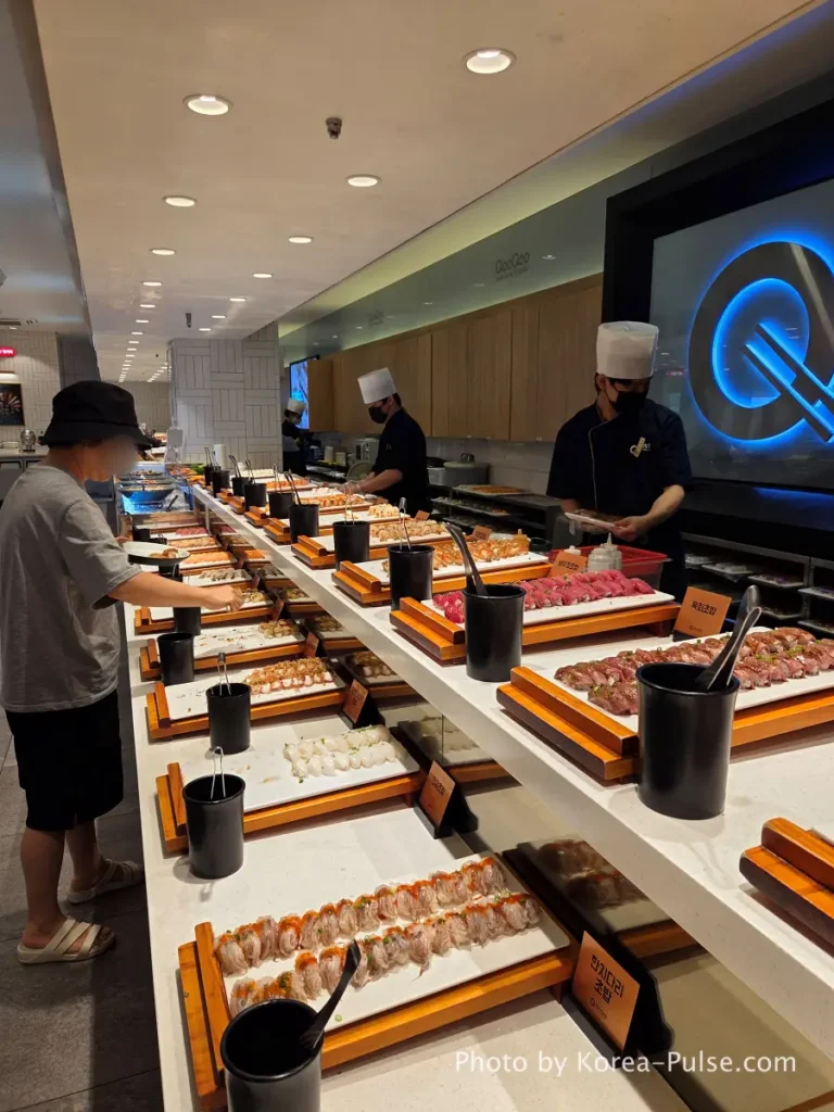 The 120-Dish Question: Inside QooQoo, Korea's Sushi Buffet Phenomenon 11 Long sushi counter with dozens of nigiri varieties at QooQoo Korean sushi buffet