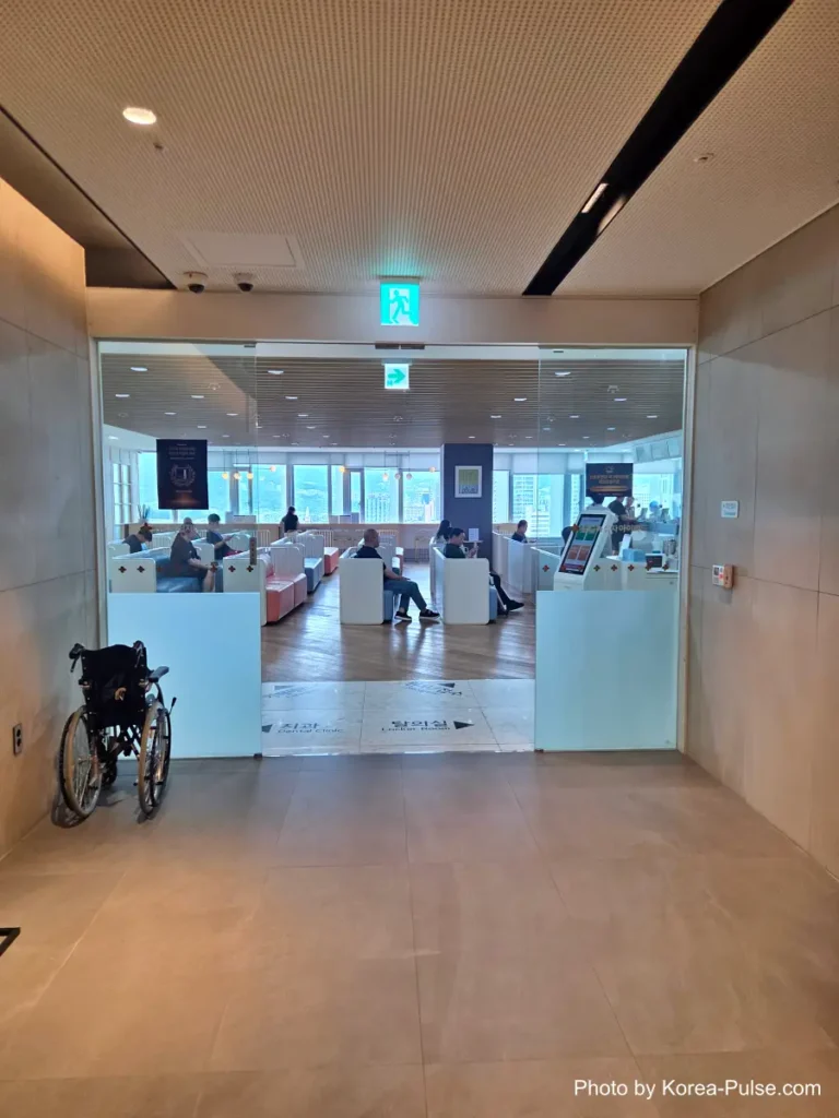 Inside Korea's 2-Hour Health Checkup Machine: Wristbands, Yellow Lines, and a Bowl of Porridge 1 Minimalist elevator lobby with a wheelchair-accessibility symbol on the floor, leading to a Korean health checkup center