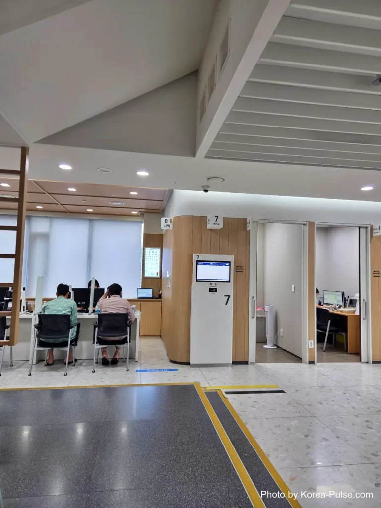 Inside Korea's 2-Hour Health Checkup Machine: Wristbands, Yellow Lines, and a Bowl of Porridge 9 Vision test station at a Korean health checkup center with an eye chart and automated testing machines